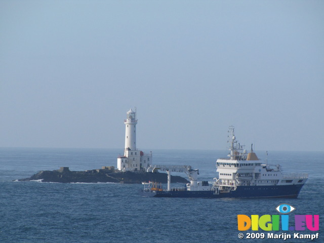 SX03065 Ship sailing past lighthouse on rocky outcrop near Rosslare (Tuskar Rock)